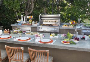 table set with stainless steel grill in an outdoor kitchen