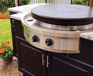 black grill with stainless steel round and quartz top on back patio